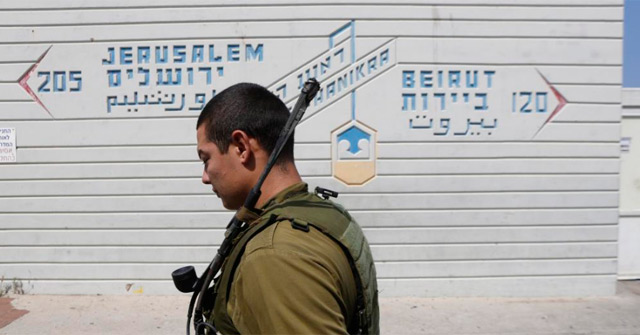 Un soldado israelí pasa junto a una señal que indica la distancia a Beirut. | Reuters