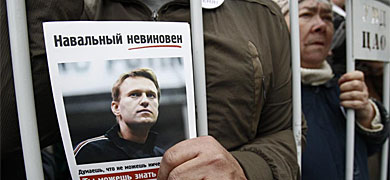 Un hombre, con una foto de Alexey Navalny.| Reuters