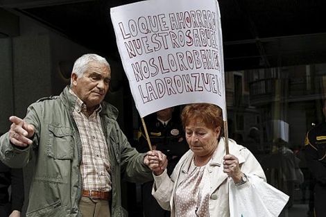 Dos jubilados, tras intentar entrar sin xito en una de las sucursales de Bankia. | Di Lolli