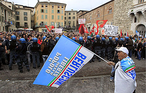 Un partidario de Berlusconi, mientras la polica bloquea a sus detractores. | Reuters