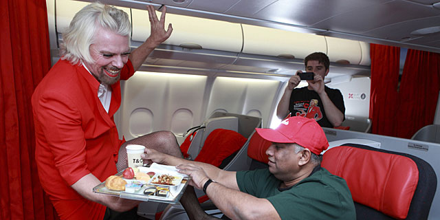 Richard Branson sirve un refrigerio a Tony Fernandes. | Air Asia/Reuters