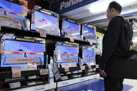 Un cliente ante varias televisiones en una tienda de Tokio. | Efe