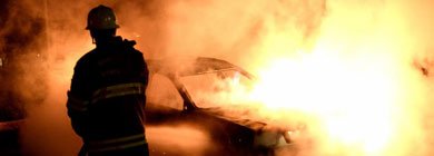 Un bombero intenta apagar un coche incendiado en Estocolmo. | Afp