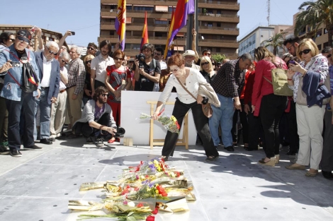 Una mujer coloca flores sobre el memorial inaugurado. | P.Rubio
