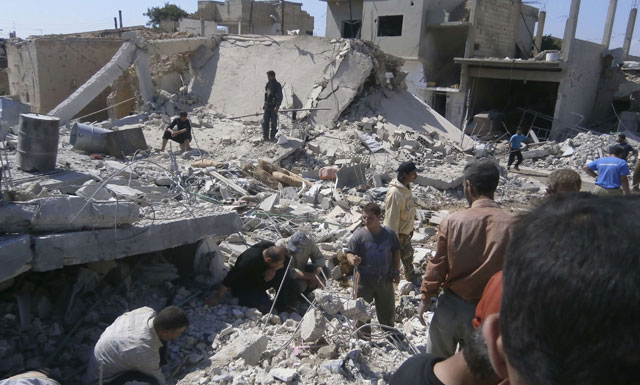Hombres buscan entre los escombros intentando localizar posibles supervivientes en Al Quseir. | Reuters