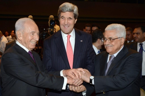 John Kerry (en el centro) une sus manos con Simon Peres (i) y Abu Mazen (d). | Afp