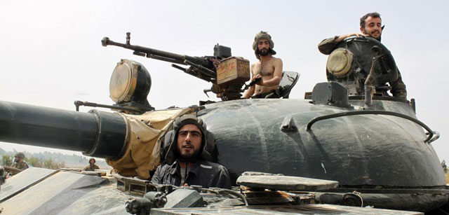 Tres soldados de las fuerzas armadas de Bashar Asad, dentro de un tanque. | Reuters