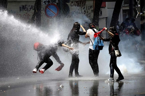La policía alcanza a un grupo de manifestantes con cañones de agua. | Afp