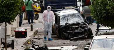 Un polica examina los restos de la bomba junto al coche afectado. | Reuters