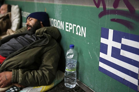 Un 'sin techo' duerme en la calle en el centro de la capital griega, Atenas. | Reuters
