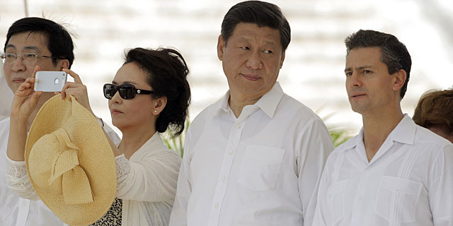 Peng Liyuan (i) hace una foto mientras su marido habla con Pea Nieto. | Reuters