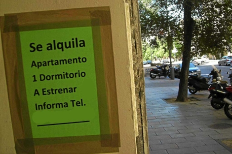 Cartel de 'Se alquila' en la entrada a un bloque de viviendas. | ELMUNDO.es