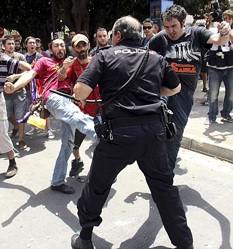 Enfrentamiento entre manifestantes y un policía. | Morell / Efe