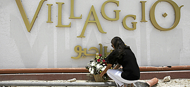 Una mujer coloca flores en memoria de los fallecidos. | Reuters