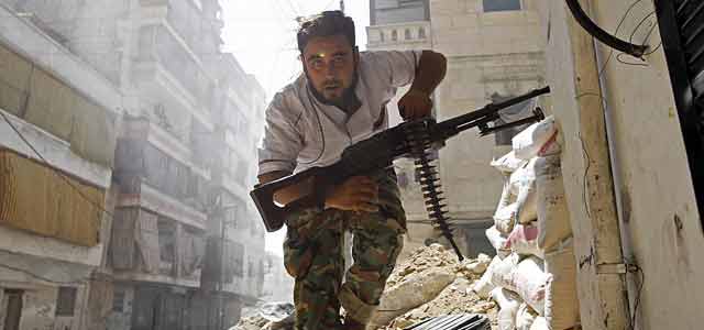 Un rebelde sirio se pone a cubierto en el centro de Alepo. | Reuters