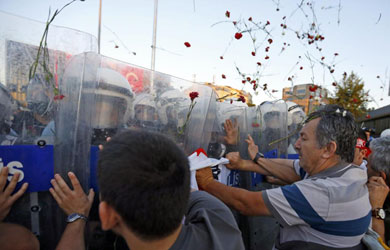 Manifestantes frenan a los agentes en medio de una lluvia de claveles. | Reuters