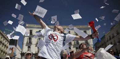 Manifestantes lanzan octavillas eb la Puerta del Sol. | Gonzalo Arroyo