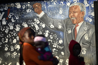 Unos nios pasan ante un mural de Mandela. | Reuters