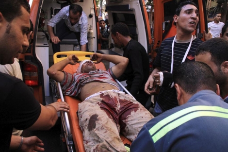 Un herido en los enfrentamientos entra en la ambulancia. | Efe