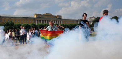 Una activista ondea una bandera arcoiris entre humo. | Afp MS IMGENES
