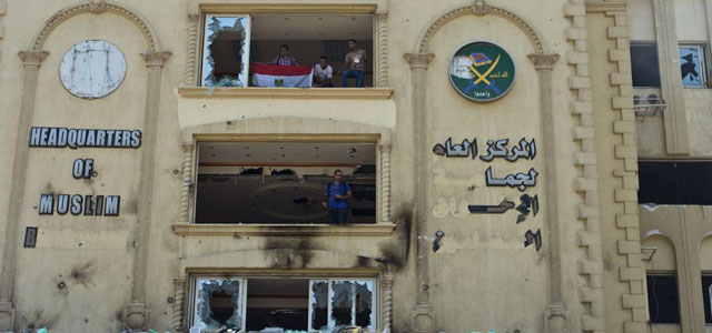Opositores en la sede de los Hermanos Musulmanes en El Cairo, que ha sido incendiada. | Afp