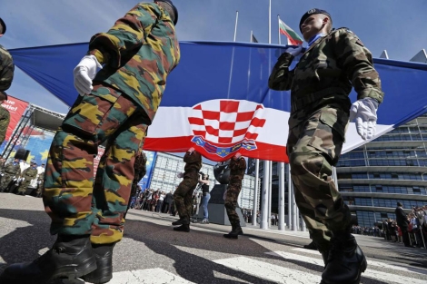 Soldados europeos sostienen la bandera de Croacia frente al Parlamento de la UE.| Reuters