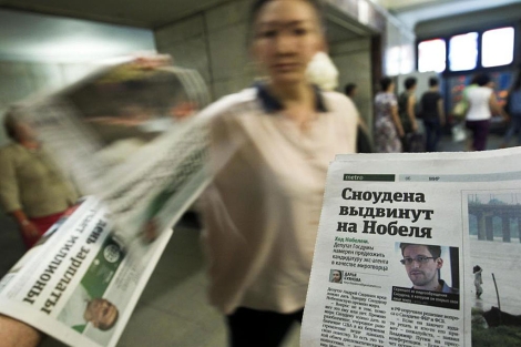 Una empleada distribuye peridicos donde aparece la imagen de Snowden, en Mosc. | Reuters