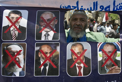 Un egipcio sostiene una pancarta con los ex gobernantes. [MS IMGENES]
