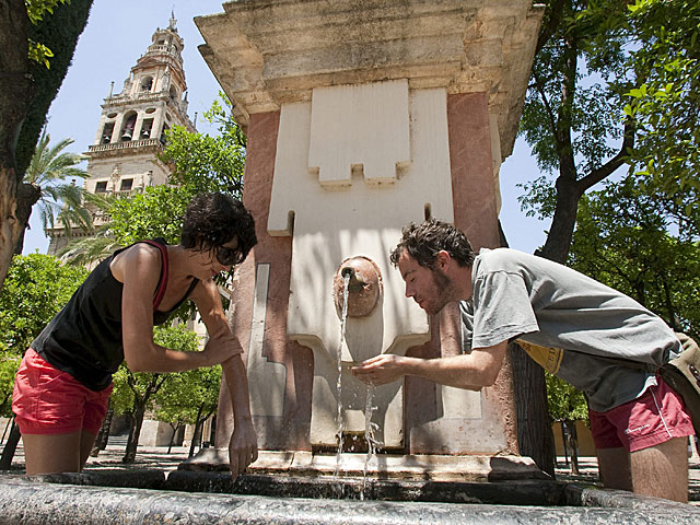Dos turistas se refrescan en una fuente de Crdoba. | Madero Cubero