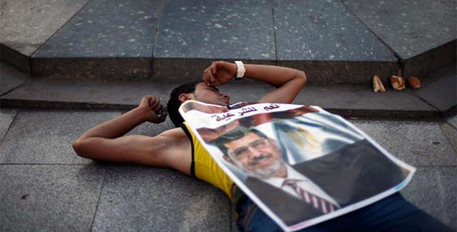 Un manifestante con una imagen de Mursi cerca de la universidad. | Reuters