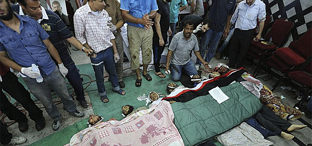 Activistas de los Hermanos Musulmanes rodean los cadveres de varios simpatizantes del depuesto presidente.| Efe