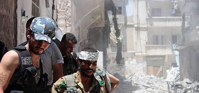 Rebeldes sirios en una calle destrozada en Alepo. | Afp