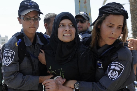 Dos policas arrestan a una manifestante musulmana en Israel.| Afp