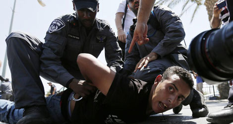 Dos policas le ponen las esposas a un manifestante que est en suelo.| Reuters