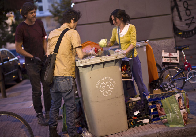 Miembros del colectivo 'Comida Basura' recogen alimentos de los contenedores. | Di Lolli