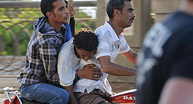 Dos hombres se llevan a un detractor de Mursi herido en El Cairo. | Afp