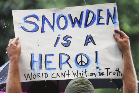 Un manifestante levanta una pancarta en la que se lee: "Snowden en un hroe".| Afp