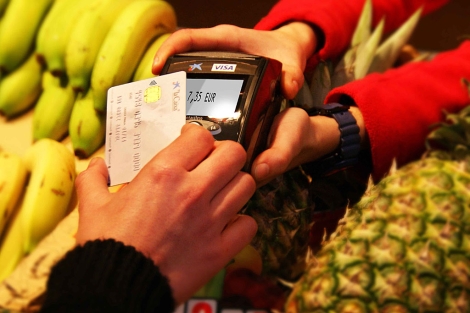 Una clienta paga en una frutera con tarjeta de crdito.