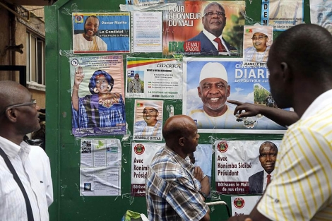 Un grupo de malienses mira los carteles de los candidatos a las presidenciales. | Afp