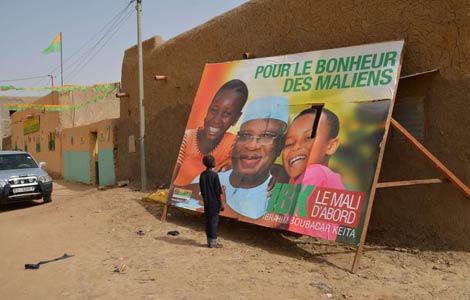 Un nio frente a un cartel del partido del candidato Ibrahim Boubacar Keita. | Afp