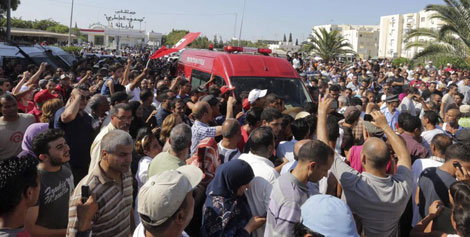 Los manifestantes se agolpan contra la ambulancia que lleva el cuerpo de Mohamed Brahmi.| Efe