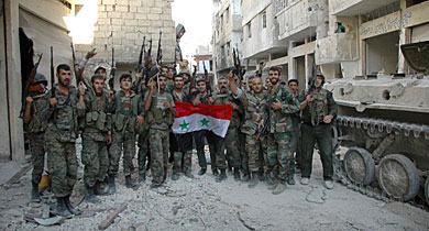 Soldados sirios celebran la victoria en el barrio clave tomado en Homs. | Reuters