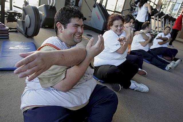 Dos jvenes con sobrepeso hacen ejercicios en un gimnasio.