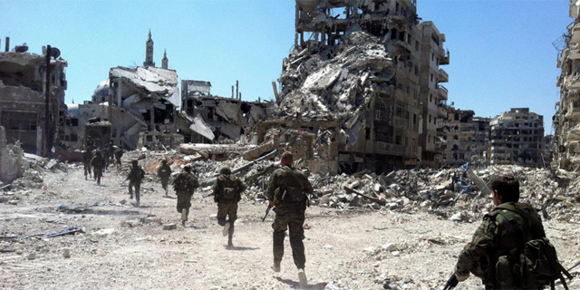 Soldados del rgimen sirio patrullan entre edificios derruidos en Homs. | Afp