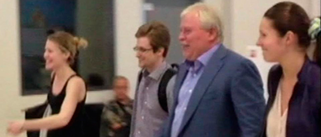El ex analista de la CIA, en el centro, abandonando el aeropuerto, ayer. | Reuters