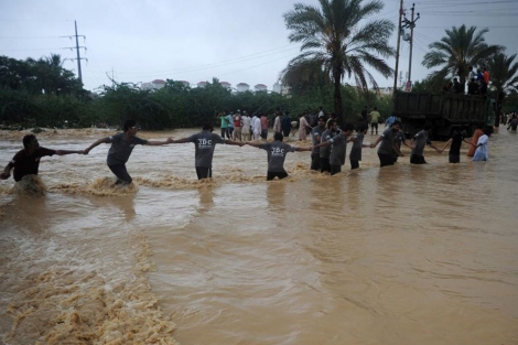 Una cadena humana para evacuar a gente de la inundacin. | Afp