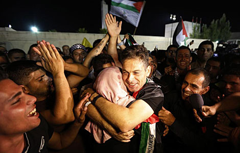 Uno de los presos liberados abraza a un familiar en West Bank. | Reuters