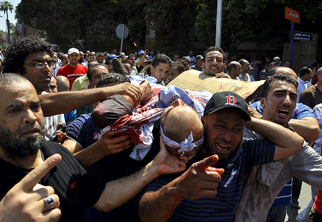 Varios manifestantes trasladan a un hombre herido durante choques en Giza. | Efe MÁS FOTOS