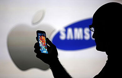 Logos de Apple y Samsung con un Galaxy S4 en primer plano. | Reuters
