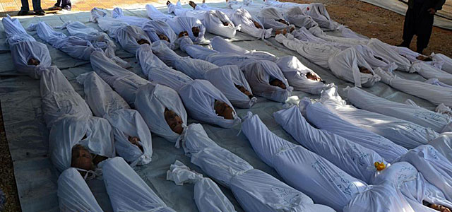 Varios cadáveres envueltos en sábanas tras el ataque. | Reuters